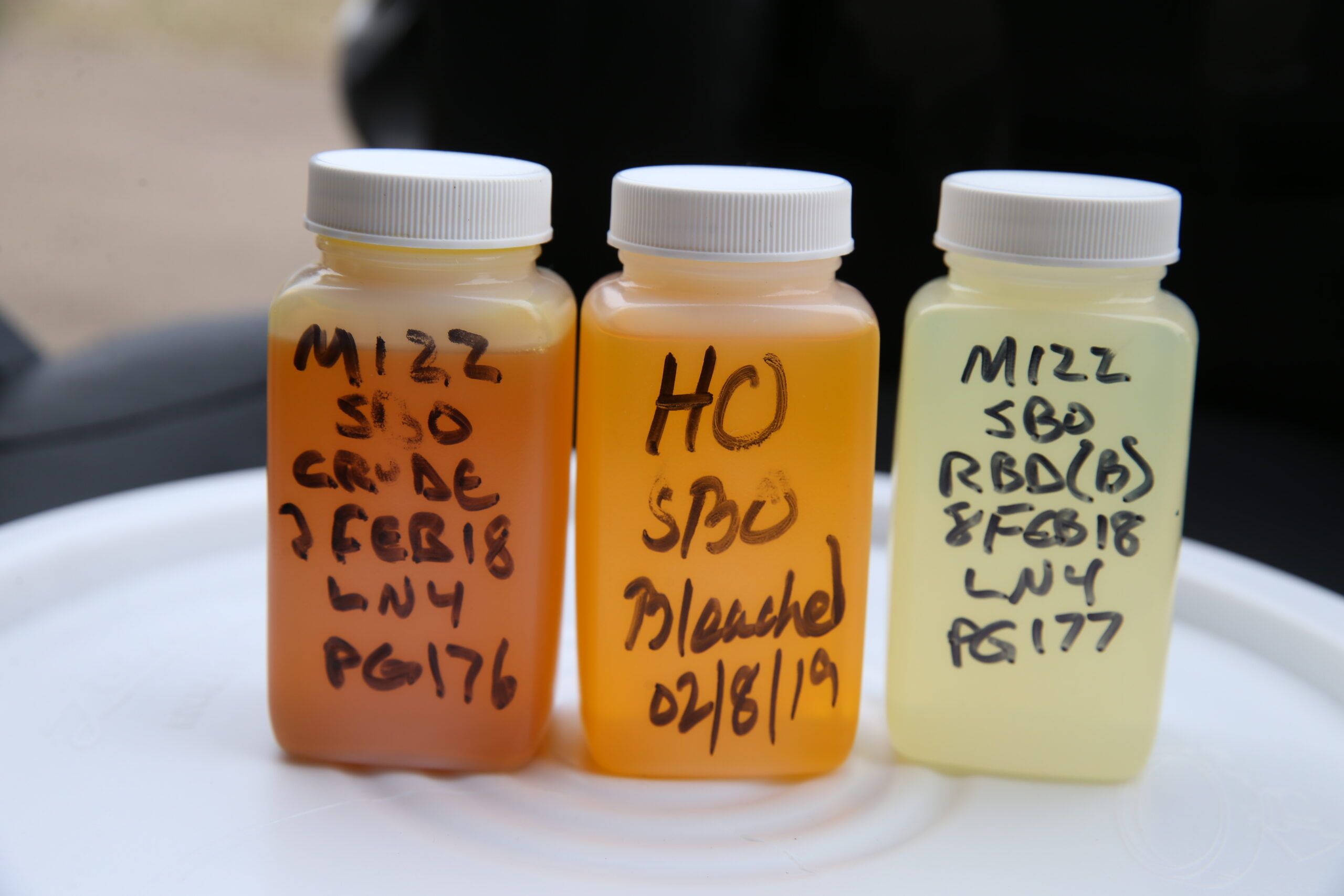 Labeled bottles getting lighter in color from left to right