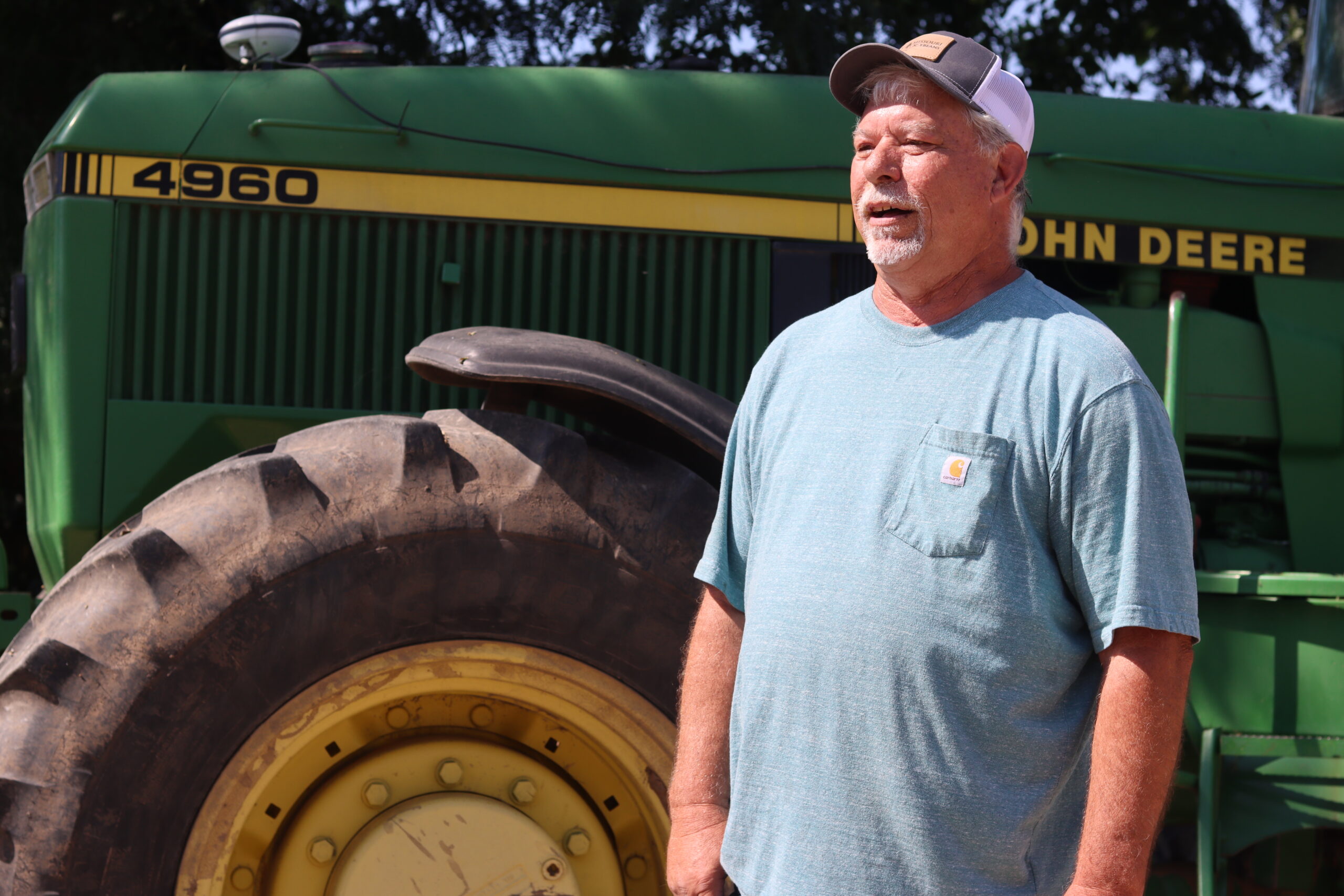 russell wolf stands in front of john deere tractor