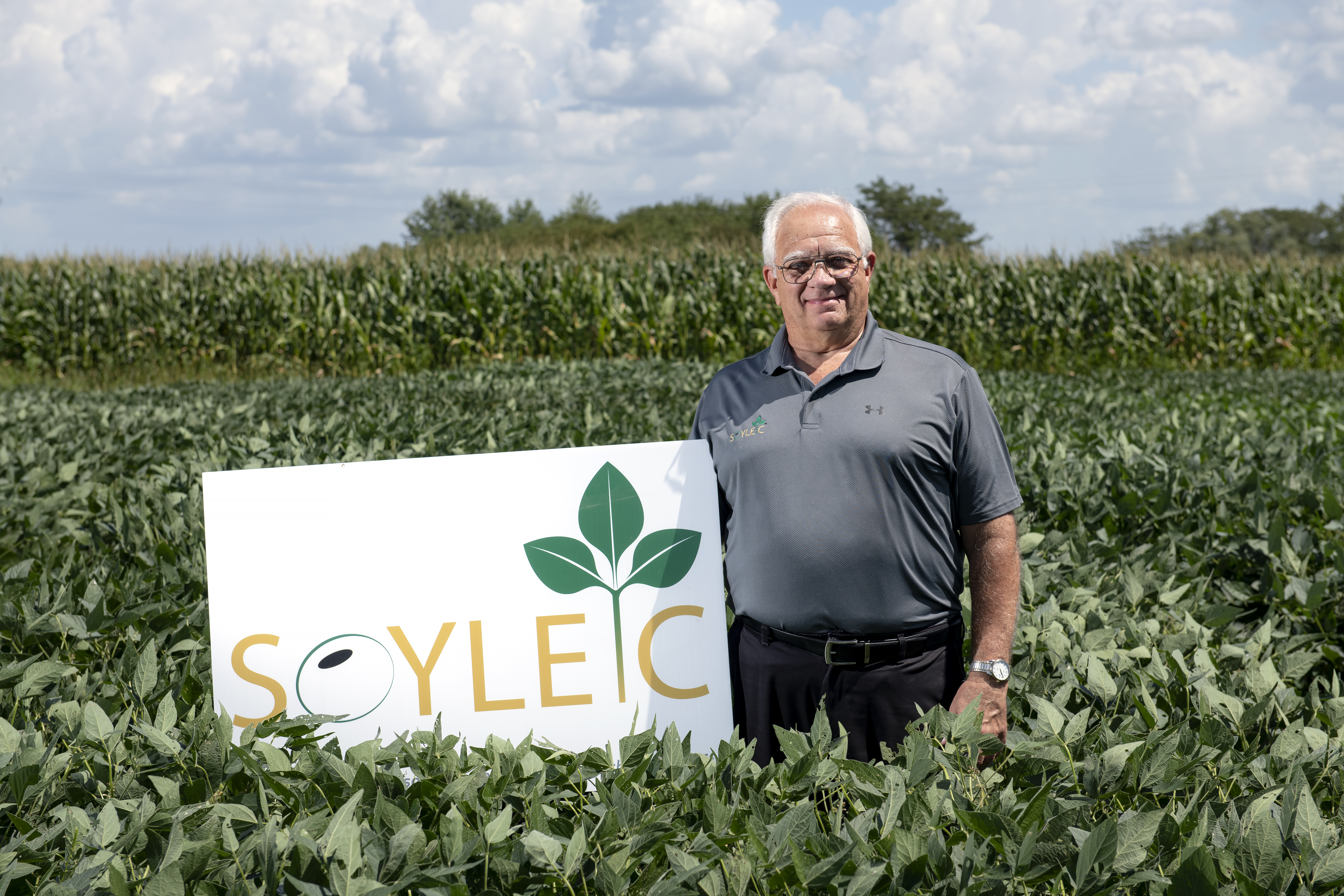 Tony Stafford standing next to a Soyleic sign in a field