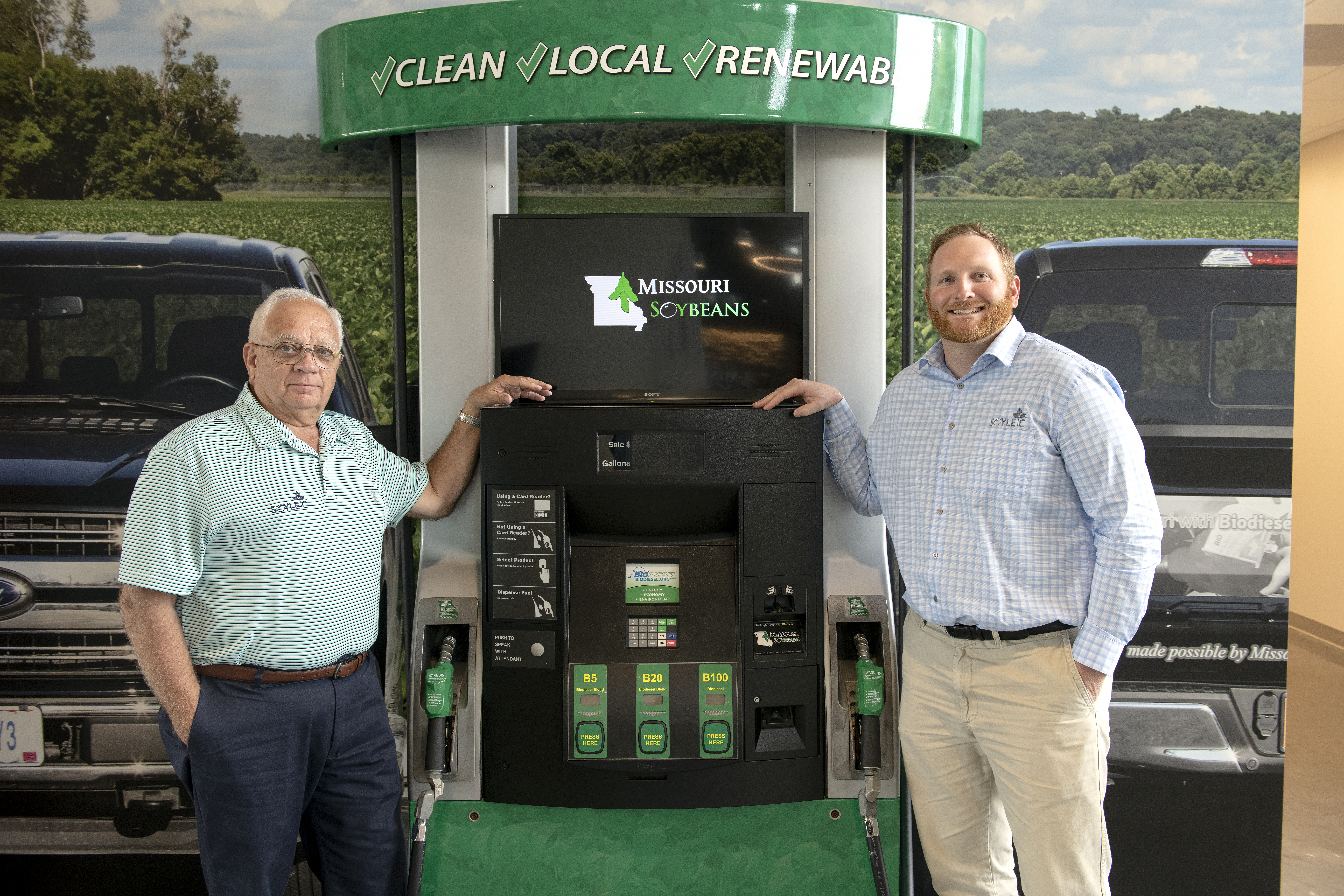 2 men standing next to a gas pump display